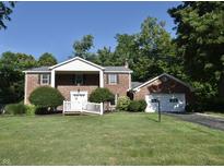 Charming two-story brick home with a well-manicured lawn, attached garage and inviting front entrance at 44 Horseshoe Ln, Carmel, IN 46033