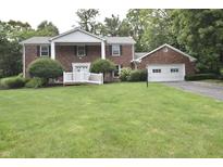 Charming two-story brick home featuring a landscaped front yard and attached garage at 44 Horseshoe Ln, Carmel, IN 46033
