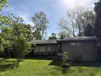Charming ranch-style home with stone facade and a well-maintained front yard and mature trees at 4609 Andover Rd, Indianapolis, IN 46226