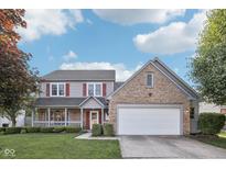 Charming two-story home featuring a brick and vinyl exterior, well-manicured lawn, and attached garage at 5269 Deer Creek Dr, Indianapolis, IN 46254