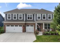 Charming two-story home with a brick and gray facade, three-car garage, and well-manicured lawn at 5917 Bartley Dr, Noblesville, IN 46062