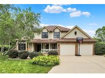 Charming two-story home with well-manicured lawn and a basketball hoop in front of the two-car garage at 6050 Acorn Dr, Columbus, IN 47201