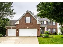 Charming brick home features a two-car garage and well-manicured lawn at 6771 Woodcliff Cir, Zionsville, IN 46077