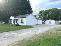 Exterior view of the house showing the gravel driveway, backyard and detached garage at 712 W Main St, Thorntown, IN 46071