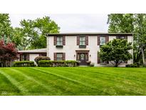 Charming two-story home with a well-manicured lawn, dark shutters, flower boxes, and a welcoming front door at 7743 Camelback Dr, Indianapolis, IN 46250