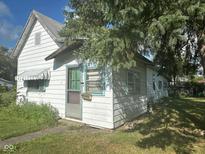 Charming vintage home featuring wood siding, covered windows, and a classic screen door entrance at 815 N 12Th St, Elwood, IN 46036