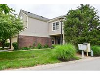 Charming two-story home with a brick and vinyl exterior, featuring a well-manicured lawn and mature trees at 9477 Aberdare N Dr, Indianapolis, IN 46250