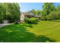 Beautifully landscaped home with a well-maintained lawn and a charming covered porch at 11059 W Old Nashville Rd, Columbus, IN 47201