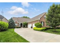 Charming brick home with a large driveway, well-manicured lawn, and lush landscaping at 15410 Mission Hills Dr, Carmel, IN 46033