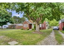 Charming brick home with a well-manicured lawn and a large tree providing ample shade at 241 Wehmeier St, Columbus, IN 47201
