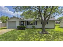 Charming home with a well-maintained front yard, mature tree, and attached garage at 3019 E Berwyn St, Indianapolis, IN 46203