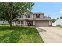 Charming two-story home with a well-manicured lawn and an attached two-car garage, creating a welcoming curb appeal at 317 Virginia St, Fortville, IN 46040