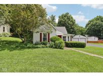 Charming single-story home with mature landscaping, red shutters, and a detached two-car garage at 409 N Sycamore St, Martinsville, IN 46151