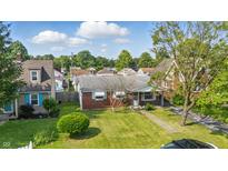 Charming brick home with a well-manicured lawn under a sunny, partly cloudy sky at 4648 Brookville Rd, Indianapolis, IN 46201