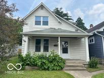 Charming two-story home featuring a covered front porch and a well-maintained front yard at 521 N Alton Ave, Indianapolis, IN 46222