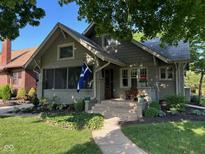 Charming home featuring a covered porch with a bench and inviting landscaped yard at 5786 N Delaware St, Indianapolis, IN 46220