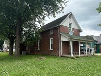 Charming brick home with a covered front porch and a spacious yard, offering classic appeal at 590 W Washington St, Martinsville, IN 46151