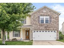 Inviting two-story home featuring a brick facade, attached two-car garage, and a well-maintained lawn at 6259 Teacup Dr, Indianapolis, IN 46235