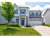 Charming two-story home featuring a well-manicured lawn, blue shutters, and a two-car garage, creating a welcoming curb appeal at 853 Woodbridge Way, Lebanon, IN 46052