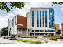 Modern commercial building with blue-tinted windows and inviting landscaping at 1 Virginia Ave # 607, Indianapolis, IN 46204