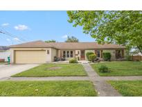 Charming brick ranch with attached garage, manicured lawn and inviting walkway to the front door at 1415 Section St, Plainfield, IN 46168