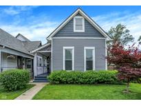 Charming gray two-story home featuring a well-maintained lawn and manicured landscaping at 1531 English Ave, Indianapolis, IN 46201