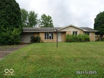 Charming single-story brick home with an inviting front yard and mature trees at 311 Fall Creek Dr, Anderson, IN 46013