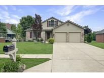 Charming two-story home with a well-manicured lawn and a two-car garage and neutral siding at 3287 Buckmoor Pkwy, Greenwood, IN 46143