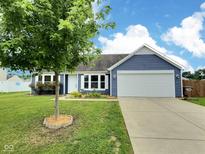 Charming blue single-story home with a well-manicured lawn, mature tree, and two-car garage at 3341 Orchard Valley Dr, Columbus, IN 47203