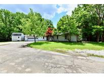 Charming single-story home featuring lush greenery, an attached garage, and a private driveway at 4115 Tansel Rd, Indianapolis, IN 46234