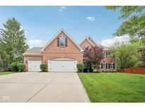 Traditional brick home boasts an attached three car garage and a well manicured front lawn at 427 Quincy Pl, Westfield, IN 46074