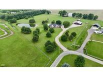 Expansive aerial view of estate with lush lawns, mature trees, pond, and elegant brick home with pool and winding driveway at 4670 N 600 E, Franklin, IN 46131
