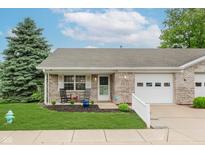 Charming brick home featuring a manicured lawn and inviting front porch with rocking chairs at 5515 Gateridge Ln, Indianapolis, IN 46237