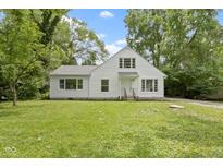 Charming white two-story home with a well-maintained front yard and surrounded by mature trees at 6833 Evanston Ave, Indianapolis, IN 46220