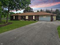 Charming brick ranch home with a long driveway and beautiful landscaping at 8433 Fairwind Ct, Indianapolis, IN 46256