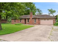 Charming brick ranch home with a well-manicured lawn and a paved driveway leading to an attached garage at 9189 Dawn Dr, Brownsburg, IN 46112