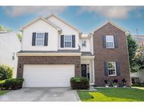 Charming two-story home featuring a brick and white exterior, attached two-car garage, and well-maintained landscaping at 13829 Black Canyon Ct, Fishers, IN 46038