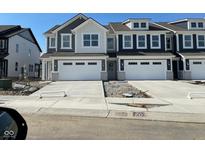 New two-story townhome with a modern garage and stylish color palette on a sunny day at 15262 Swallow Falls Way, Fishers, IN 46037