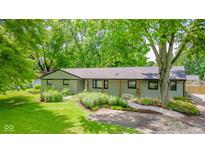 Charming single-story home featuring a well-manicured lawn and a beautiful garden at 1605 Westlane Rd, Indianapolis, IN 46260