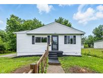 Charming one-story home with white siding, black shutters, and a well-maintained front yard at 1933 Tallman Ave, Indianapolis, IN 46218