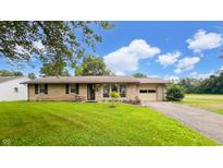 Charming single-story home with well-maintained lawn and inviting curb appeal, featuring a convenient attached garage at 202 Collier St, Columbus, IN 47201