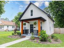 Charming renovated bungalow featuring black trim, bright orange porch supports, and fresh landscaping at 3035 Guilford Ave, Indianapolis, IN 46205