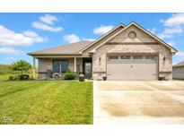 Charming brick home featuring a manicured lawn, covered porch, and an attached two-car garage at 3072 W Glacier Dr, Monrovia, IN 46157