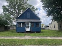 Charming blue home with a well-maintained front yard, inviting curb appeal and mature trees at 3127 E Lynn St, Anderson, IN 46016