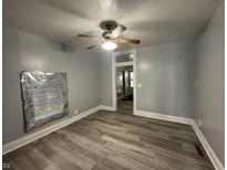Bright living room featuring light grey walls, modern floors, ceiling fan, and lots of natural light at 3127 E Lynn St, Anderson, IN 46016