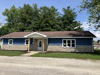 Charming single-story home with blue siding, stone accents, and a welcoming front porch at 321 S 23Rd St, Elwood, IN 46036