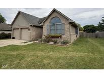 Charming brick home featuring an attached two-car garage and manicured lawn at 3327 Boxwood Dr, Indianapolis, IN 46227