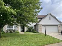Charming two-story home with a well-manicured lawn, attached two-car garage, and lush landscaping at 3610 Homestead Pl, Plainfield, IN 46168