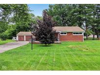 Charming brick home with a well-maintained lawn and a detached two-car garage at 3921 S Lasalle St, Indianapolis, IN 46237