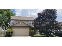 Traditional two-story home with vinyl siding and attached garage, surrounded by mature trees on a sunny day at 403 Bagley Ln, Indianapolis, IN 46231